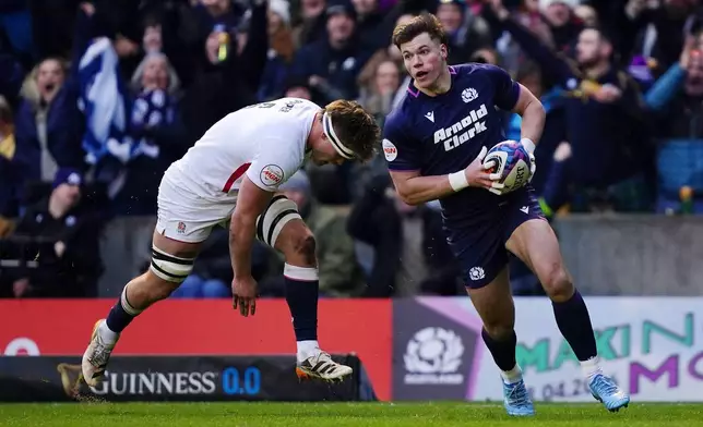 Scotland's Huw Jones, right, scores during the Six Nations rugby union match between Scotland and England in Edinburgh, Scotland, Saturday Feb. 14, 2026. (Jane Barlow/PA via AP)