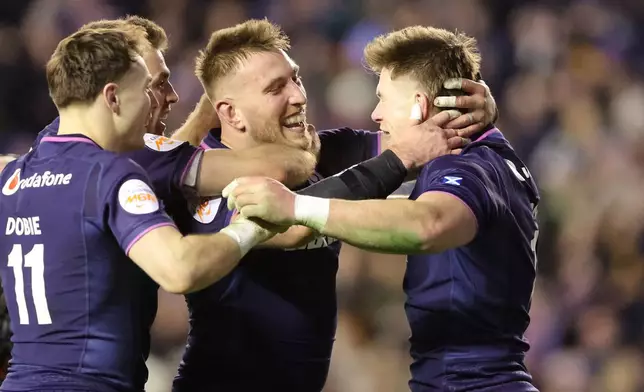 Scotland's Huw Jones, right, celebrates scoring a try with teammates during the Six Nations rugby union match between Scotland and England in Edinburgh, Scotland, Saturday Feb. 14, 2026. (Steve Welsh/PA via AP)