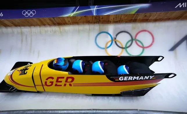 Germany's Johannes Lochner, left, Thorsten Margis, Jorn Wenzel and Georg Fleischauer slide down the track during a four man bobsled run at the 2026 Winter Olympics, in Cortina d'Ampezzo, Italy, Saturday, Feb. 21, 2026. (AP Photo/Aijaz Rahi)