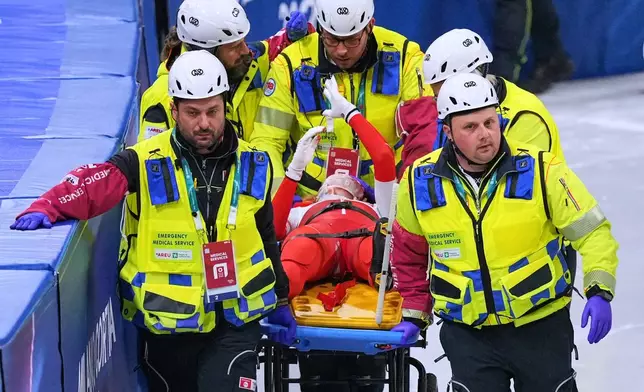 Kamila Sellier of Poland is helped after falling during a short track speed skating women's 1500 meters quarterfinal at the 2026 Winter Olympics, in Milan, Italy, Friday, Feb. 20, 2026. (AP Photo/Stephanie Scarbrough)