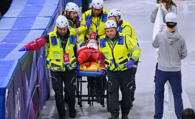 Kamila Sellier of Poland is helped after falling during a short track speed skating women's 1500 meters quarterfinal at the 2026 Winter Olympics, in Milan, Italy, Friday, Feb. 20, 2026. (AP Photo/Stephanie Scarbrough)