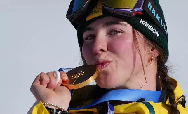 Gold medalist Australia's Josie Baff kisses her medal after winning the women's snowboard cross finals at the 2026 Winter Olympics, in Livigno, Italy, Friday, Feb. 13, 2026. (AP Photo/Julia Demaree Nikhinson)