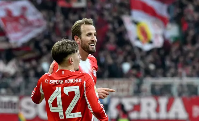 Bayern's Harry Kane, right, celebrates with Lennard Karl after scoring his side's second goal during the German Bundesliga soccer match between Werder Bremen and Bayern Munich, in Bremen, Germany, Saturday, Dec. 14, 2026. (Carmen Jaspersen/dpa via AP)