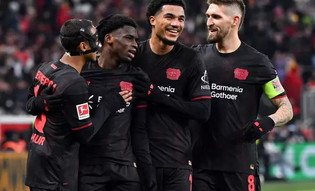 Leverkusen's Ernest Poku, second from left, celebrates with Arthur, left, Malik Tillman, centre right, and Robert Andrich after scoring his side's fourth goal during the German Bundesliga soccer match between Bayer Leverkusen and FC St. Pauli, in Leverkusen, Germany, Saturday, Dec. 14, 2026. (Federico Gambarini/dpa via AP)