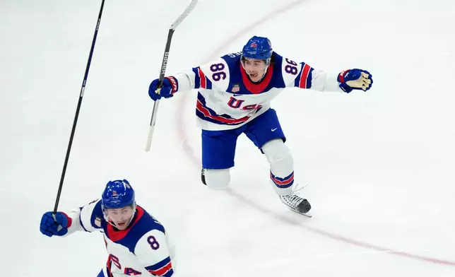 United States' Jack Hughes (86) and Zach Werenski (8) celebrate after Hughes scored the winning goal against Canada during the overtime period of the men's ice hockey gold medal game at the 2026 Winter Olympics in Milan, Italy, Sunday, Feb. 22, 2026. (AP Photo/Carolyn Kaster)