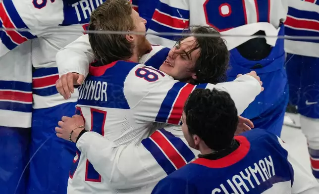 United States' Jack Hughes (86) celebrates with goalie Connor Hellebuyck (37) after scoring the game-winning goal against Canada in sudden death overtime during the men's ice hockey gold medal game at the 2026 Winter Olympics, in Milan, Italy, Sunday, Feb. 22, 2026. (AP Photo/Luca Bruno)
