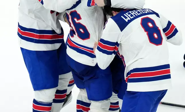 United States' JT Miller (10) and Zach Werenski (8) celebrate with Jack Hughes (86) after Hughes scored the winning goal in overtime against Canada to win the men's ice hockey gold medal game at the 2026 Winter Olympics in Milan, Italy, Sunday, Feb. 22, 2026. (AP Photo/Carolyn Kaster)