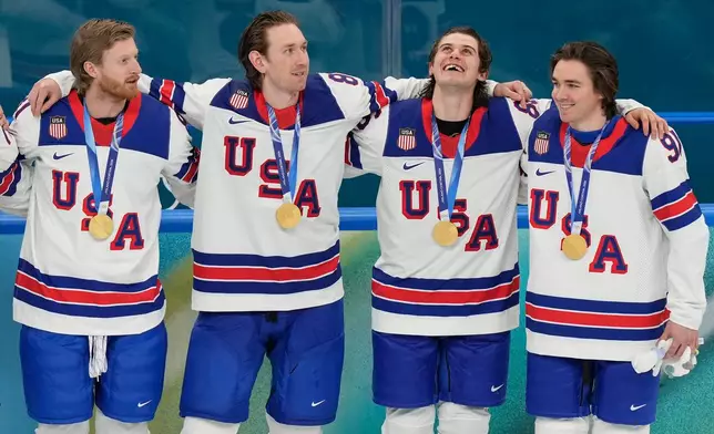 United States' Kyle Connor (81), Zach Werenski (8), Jack Hughes (86) and Clayton Keller (91) react after receiving their gold medals after the United States defeated Canada in the men's ice hockey gold medal game at the 2026 Winter Olympics, in Milan, Italy, Sunday, Feb. 22, 2026. (AP Photo/Luca Bruno)