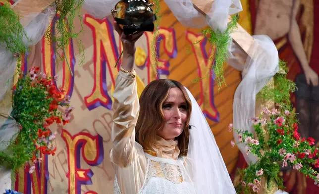 Rose Byrne, Hasty Pudding 2026 Woman of the Year, holds the Pudding Pot while wearing a wedding gown costume as she participates in a skit during a roast at Farkas Hall theater, Friday, Feb. 13, 2026, in Cambridge, Mass. (AP Photo/Steven Senne)