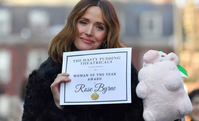 Rose Byrne, center, Hasty Pudding 2026 Woman of the Year, displays a certificate following a parade, Friday, Feb. 13, 2026, through Harvard Square, in Cambridge, Mass. (AP Photo/Steven Senne)