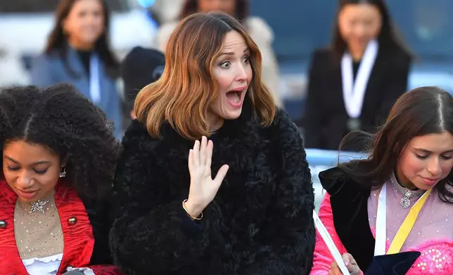 Rose Byrne, center, Hasty Pudding 2026 Woman of the Year, waves while riding in a convertible with Harvard University theatrical students Isabel Wilson, left, and Daisy Nussbaum, right, during a parade, Friday, Feb. 13, 2026, through Harvard Square, in Cambridge, Mass. (AP Photo/Steven Senne)