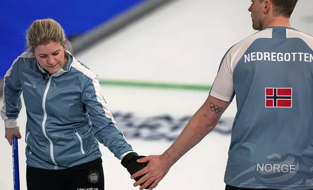 Norway's Magnus Nedregotten and Kristin Skaslien gesture, during the mixed doubles round robin phase of the curling competition against Czechia, at the 2026 Winter Olympics, in Cortina d'Ampezzo, Italy, Sunday, Feb. 8, 2026. (AP Photo/Fatima Shbair)