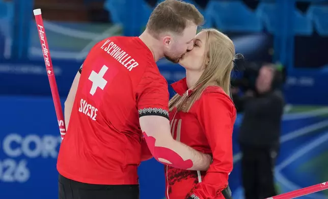 Switzerland's Yannick Schwaller, left, celebrates with Briar Schwaller-Huerlimann, after winning the mixed doubles round robin phase of the curling competition against south Korea at the 2026 Winter Olympics, in Cortina d'Ampezzo, Italy, Thursday, Feb. 5, 2026. (AP Photo/Misper Apawu)
