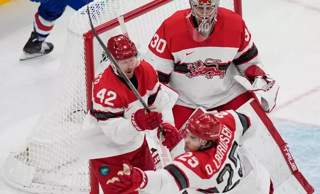 Denmark's Oliver Lauridsen reaches for the puck during a preliminary round match of men's ice hockey between United States and Denmark at the 2026 Winter Olympics, in Milan, Italy, Saturday, Feb. 14, 2026. (AP Photo/Petr David Josek)