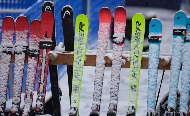 Snow-covered skis are lined up at the finish area of an alpine ski, men's slalom race, at the 2026 Winter Olympics, in Bormio, Italy, Monday, Feb. 16, 2026. (AP Photo/Rebecca Blackwell)