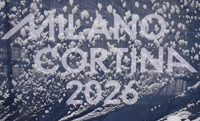 Olympic signage is covered in snow at the finish area of an alpine ski, men's slalom race, at the 2026 Winter Olympics, in Bormio, Italy, Monday, Feb. 16, 2026. (AP Photo/Rebecca Blackwell)