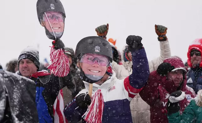 Fans for United States' Kyra Dossa brave heavy snow during a weather delay before women's freestyle skiing aerials qualifications at the 2026 Winter Olympics, in Livigno, Italy, Tuesday, Feb. 17, 2026. (AP Photo/Gregory Bull)
