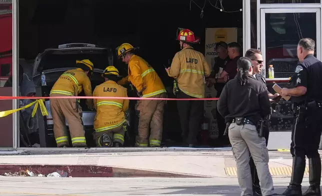 First responders gather around a car seen inside of a 99 Ranch Market at the scene of a fatal crash Thursday, Feb. 5, 2026, in the Westwood neighborhood of Los Angeles.(AP Photo/Damian Dovarganes)