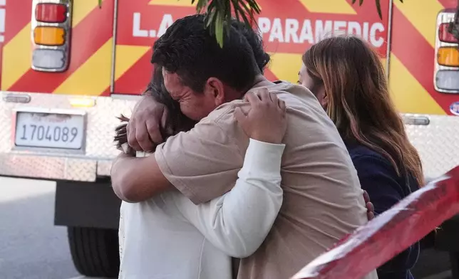 People embrace at the scene of a fatal crash outside of a 99 Ranch Market, Thursday, Feb. 5, 2026, in the Westwood neighborhood of Los Angeles.(AP Photo/Damian Dovarganes)
