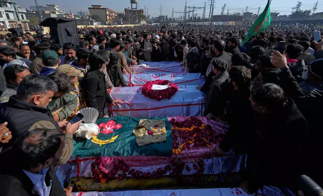 Mourners arrange the coffins of the victims of Friday's suicide bombing inside a Shiite mosque, during a funeral prayer, in Islamabad, Pakistan, Saturday, Feb. 7, 2026. (AP Photo/Anjum Naveed)