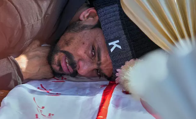 A man mourns over coffin of his relative, who was killed in Friday's suicide bombing inside a Shiite mosque, in Islamabad, Pakistan, Saturday, Feb. 7, 2026. (AP Photo/Anjum Naveed)