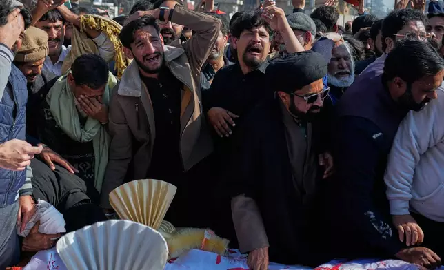 People mourn next the coffin of their relatives, who were killed in Friday's suicide bombing inside a Shiite mosque, in Islamabad, Pakistan, Saturday, Feb. 7, 2026. (AP Photo/Anjum Naveed)