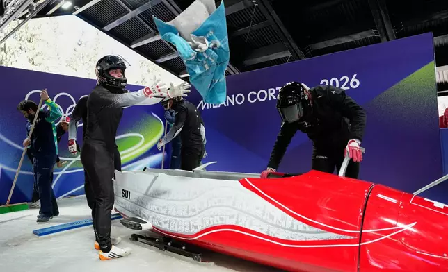 Switzerland's Michael Vogt and his team prepare to start for a four man bobsled training session at the 2026 Winter Olympics, in Cortina d'Ampezzo, Italy, Wednesday, Feb. 18, 2026. (AP Photo/Alessandra Tarantino)
