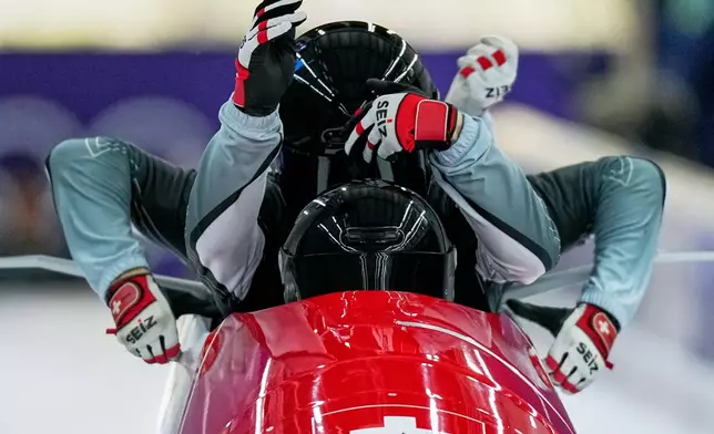 Switzerland's Timo Rohner, front, starts for a four man bobsled training session at the 2026 Winter Olympics, in Cortina d'Ampezzo, Italy, Wednesday, Feb. 18, 2026. (AP Photo/Aijaz Rahi)
