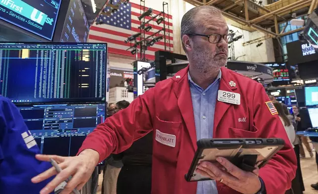 Trader William Lawrence works on the floor of the New York Stock Exchange, Friday, Feb. 13, 2026, in New York. (AP Photo/Richard Drew)