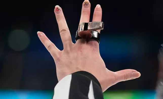 A referee signals with her hand during a women's ice hockey bronze medal game between Switzerland and Sweden at the 2026 Winter Olympics, in Milan, Italy, Thursday, Feb. 19, 2026. (AP Photo/Hassan Ammar)