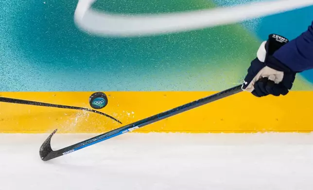 Finland's Miro Heiskanen (41), right, tries to control the puck during a men's ice hockey quarterfinal game between Finland and Switzerland at the 2026 Winter Olympics, in Milan, Italy, Wednesday, Feb. 18, 2026. (AP Photo/Petr David Josek)