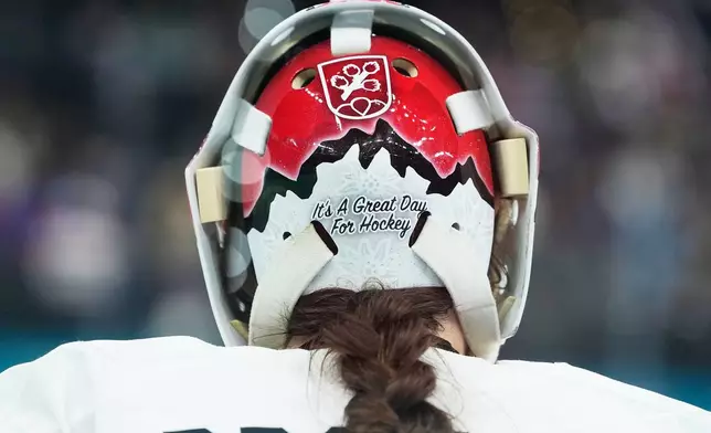 Switzerland's Andrea Braendli (20) sports a message on her helmet during a women's ice hockey bronze medal game between Switzerland and Sweden at the 2026 Winter Olympics, in Milan, Italy, Thursday, Feb. 19, 2026. (AP Photo/Petr David Josek)