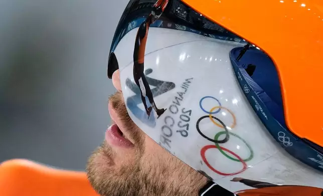 The Olympic Rings are reflected in the vizor of the helmet of Chris Huizinga of the Netherlands ahead of the men's team pursuit quarterfinals speedskating race at the 2026 Winter Olympics, in Milan, Italy, Sunday, Feb. 15, 2026. (AP Photo/Luca Bruno)