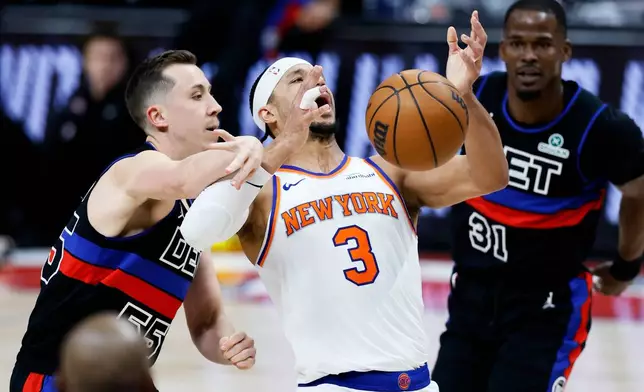 Detroit Pistons forward Duncan Robinson (55) knocks the ball away from New York Knicks guard Josh Hart (3) during the first half of an NBA basketball game Friday, Feb. 6, 2026, in Detroit. (AP Photo/Duane Burleson)