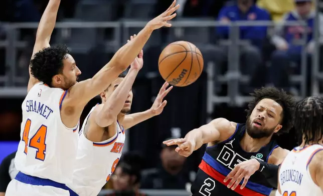 Detroit Pistons guard Cade Cunningham (2) passes the ball against New York Knicks guard Landry Shamet (44) and guard Kevin McCullar Jr. (9) during the first half of an NBA basketball game Friday, Feb. 6, 2026, in Detroit. (AP Photo/Duane Burleson)