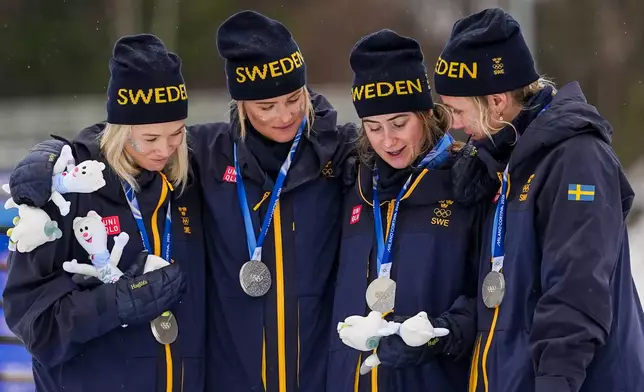 Jonna Sundling, Frida Karlsson, Ebba Andersson, and Linn Svahn, of Sweden, stands on the podium after winning the silver medal in the cross country skiing women's 4 x 7.5km relay at the 2026 Winter Olympics, in Tesero, Italy, Saturday, Feb. 14, 2026. (AP Photo/Matthias Schrader)