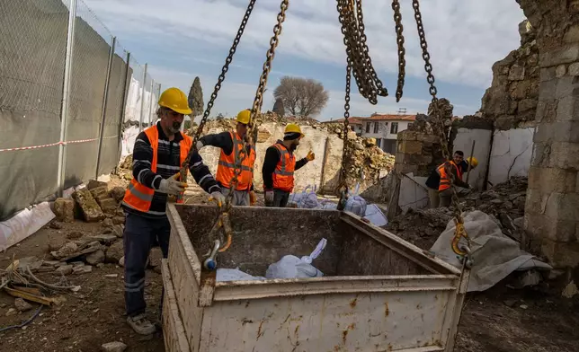 Workers clear rubble and salvage stones from the ruins of St. Paul's Greek Orthodox Church, damaged in the 2023 earthquake, in the city of Antakya, southern Turkey, Wednesday, Feb. 4, 2026. (AP Photo/Murat Kocabas)