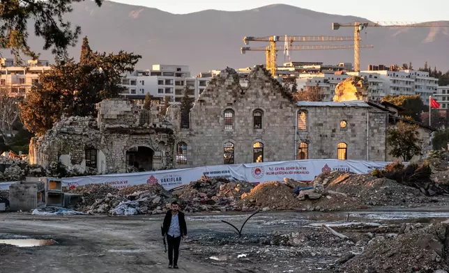 A man walks past the ruins of St. Paul Orthodox Church during debris removal efforts following the February 2023 earthquakes in Antakya, southern Turkey, Wednesday, Feb. 4, 2026. (AP Photo/Murat Kocabas)