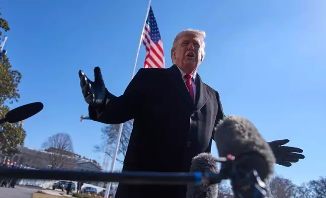 President Donald Trump speaks with reporters before boarding Marine One on the South Lawn of the White House, Friday, Feb. 13, 2026, in Washington. (AP Photo/Evan Vucci)