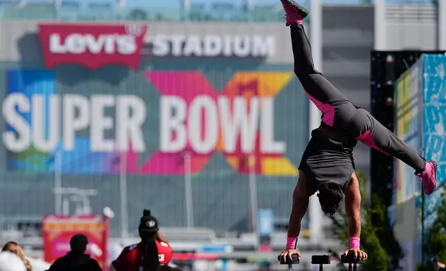 A performer balances outside Levi's Stadium before the NFL Super Bowl 60 football game between the Seattle Seahawks and the New England Patriots, Sunday, Feb. 8, 2026, in Santa Clara, Calif. (AP Photo/Julio Cortez)