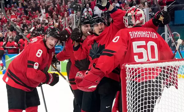 Canada players celebrate at the end of a men's ice hockey semifinal game between Canada and Finland at the 2026 Winter Olympics, in Milan, Italy, Friday, Feb. 20, 2026. (AP Photo/Hassan Ammar)
