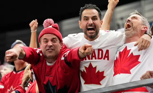 Canada supporters celebrate after Canada's Shea Theodore (27) scored his side's second goal during a men's ice hockey semifinal game between Canada and Finland at the 2026 Winter Olympics, in Milan, Italy, Friday, Feb. 20, 2026. (AP Photo/Hassan Ammar)