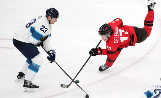 Canada's Macklin Celebrini (17) tries to get a shot away as he is defended by Finland's Esa Lindell (23) during the first period of a men's ice hockey semifinal game at the 2026 Winter Olympics in Milan, Italy, Friday, Feb. 20, 2026. (AP Photo/Carolyn Kaster)