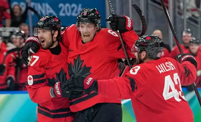 Canada's Shea Theodore (27) celebrates with teammates after scoring his side's second goal during a men's ice hockey semifinal game between Canada and Finland at the 2026 Winter Olympics, in Milan, Italy, Friday, Feb. 20, 2026. (AP Photo/Petr David Josek)
