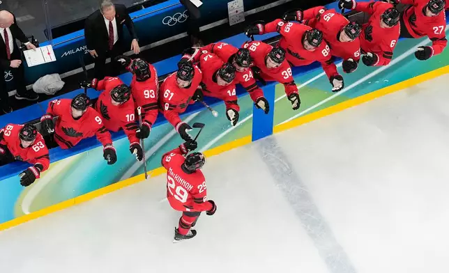 Canada's Nathan MacKinnon (29) celebrates with teammates after scoring the game-winning goal against Finland during a men's semifinal ice hockey game at the 2026 Winter Olympics, in Milan, Italy, Friday, Feb. 20, 2026. (AP Photo/David J. Phillip)