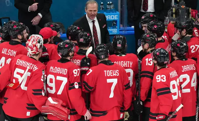 Canada head coach Jon Cooper talks with his players after their win against Finland in a men's ice hockey semifinal game at the 2026 Winter Olympics in Milan, Italy, Friday, Feb. 20, 2026. (AP Photo/Carolyn Kaster)