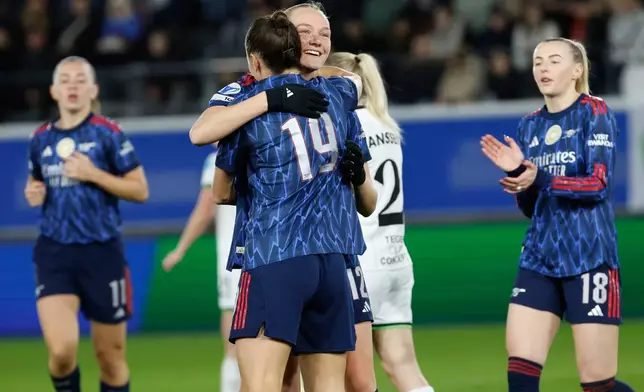 Arsenal's Frida Maanum, second left, is congratulated by teammate Arsenal's Caitlin Foord after scoring her sides third goal during the women's Champions League knockout play-off soccer match between OH Leuven and Arsenal in Leuven, Belgium, Wednesday, Feb. 11, 2026. (AP Photo/Geert Vanden Wijngaert)
