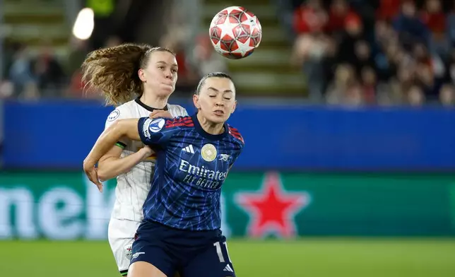 Leuven's Alixe Bosteels, left, fights for the ball against Arsenal's Katie McCabe during the women's Champions League knockout play-off soccer match between OH Leuven and Arsenal in Leuven, Belgium, Wednesday, Feb. 11, 2026. (AP Photo/Geert Vanden Wijngaert)
