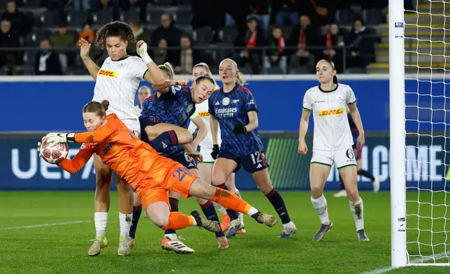 Leuven's goalkeeper Lowiese Seynhaeve, left, goes out for a save as she is challenged by Arsenal's Caitlin Foord, center, during the women's Champions League knockout play-off soccer match between OH Leuven and Arsenal in Leuven, Belgium, Wednesday, Feb. 11, 2026. (AP Photo/Geert Vanden Wijngaert)