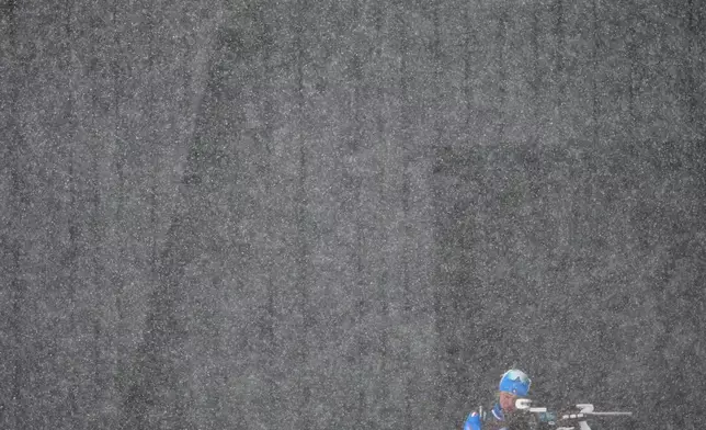 An Italian athlete trains before the men's 4 x 7.5km biathlon relay as heavy snow falls at the 2026 Winter Olympics, in Anterselva, Italy, Tuesday, Feb. 17, 2026. (AP Photo/Christophe Ena)